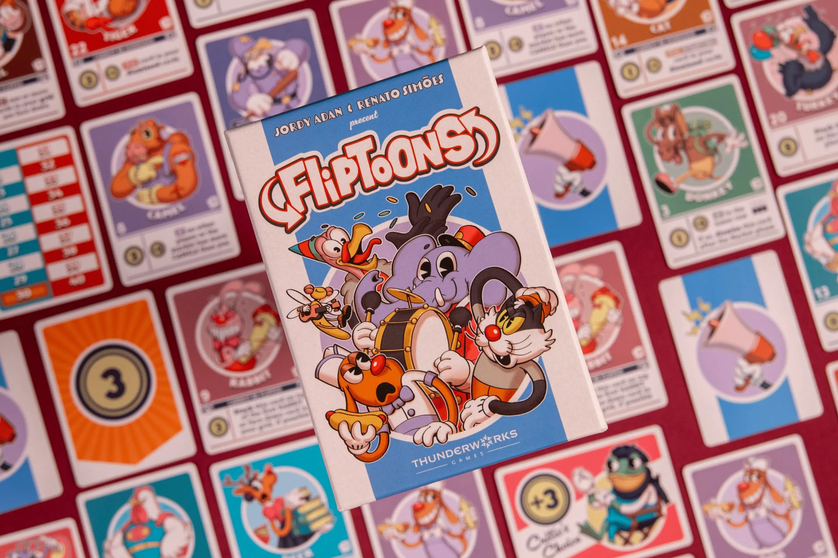 Caixa do FlipToons sobre cartas do jogo espalhadas